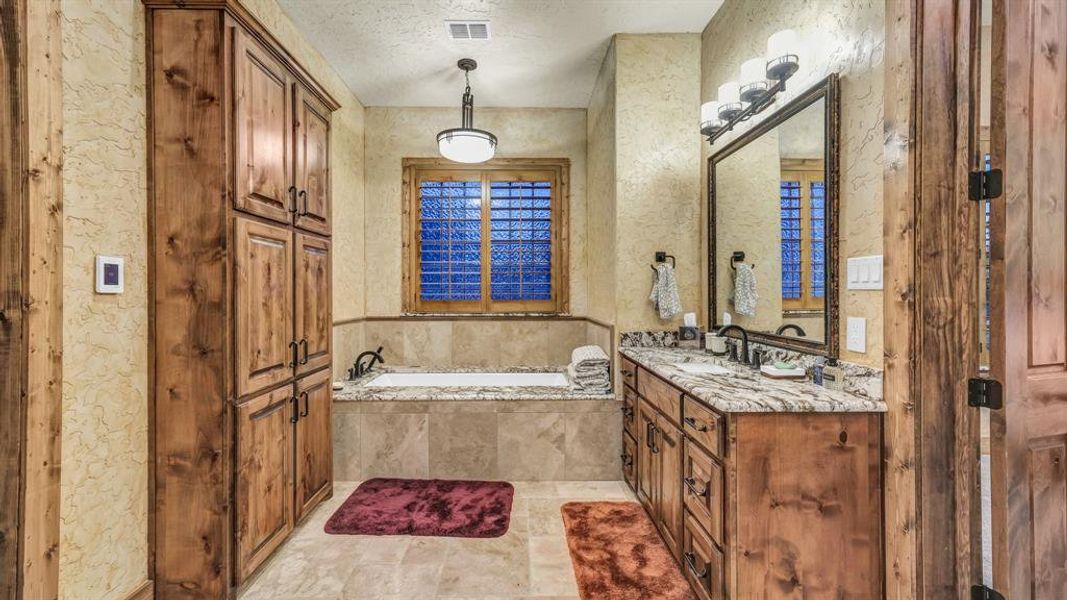 Relaxing soaking tub framed with tile surround, complemented by a large window with privacy glass.
