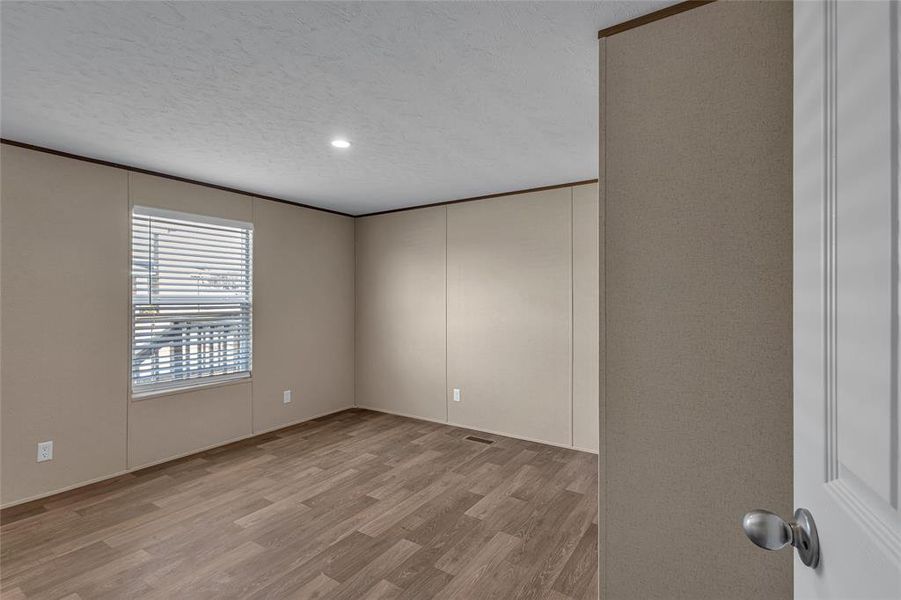 Unfurnished room featuring a textured ceiling and light hardwood / wood-style floors