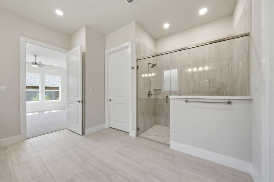 Oversized walk-in shower with sleek tile surround and modern finishes.