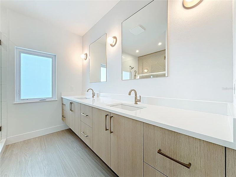 Spa-like en-suite bath featuring dual sinks, an oversized walk-in shower, and a private water closet. Spa-like en-suite bath featuring dual sinks, an oversized walk-in shower, and a private water closet.