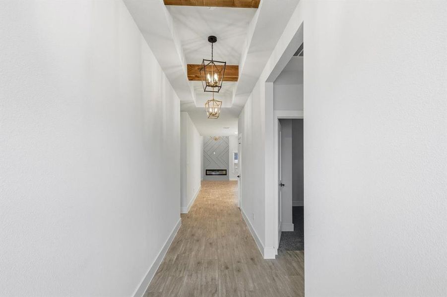 Hallway featuring light wood-type flooring and a chandelier
