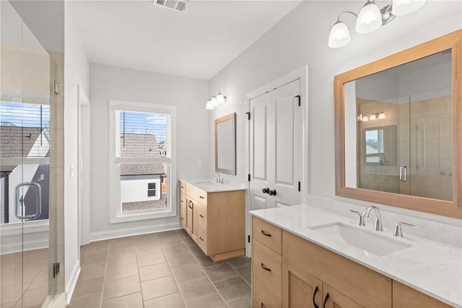 The home features dual vanities in the master bathroom, designed to provide convenience and luxury for everyday use. Each vanity offers its own spacious countertop, allowing for ample space for personal items and grooming essentials.. Not actual home. Ph