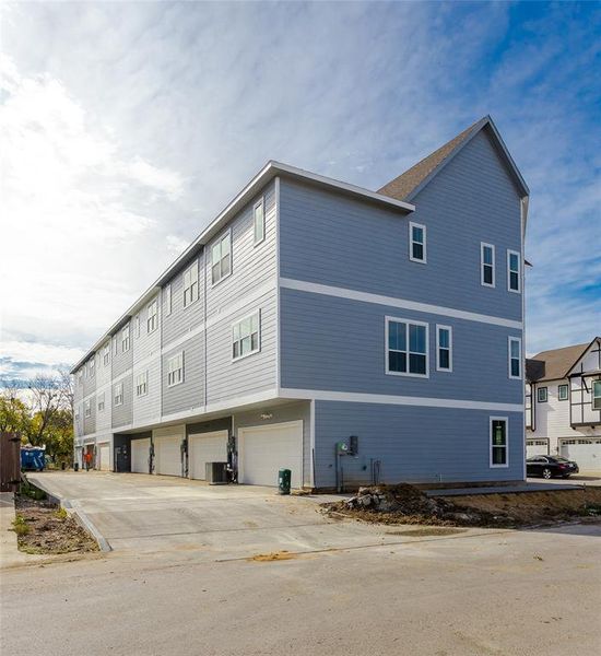 View of side of home with central AC and a garage