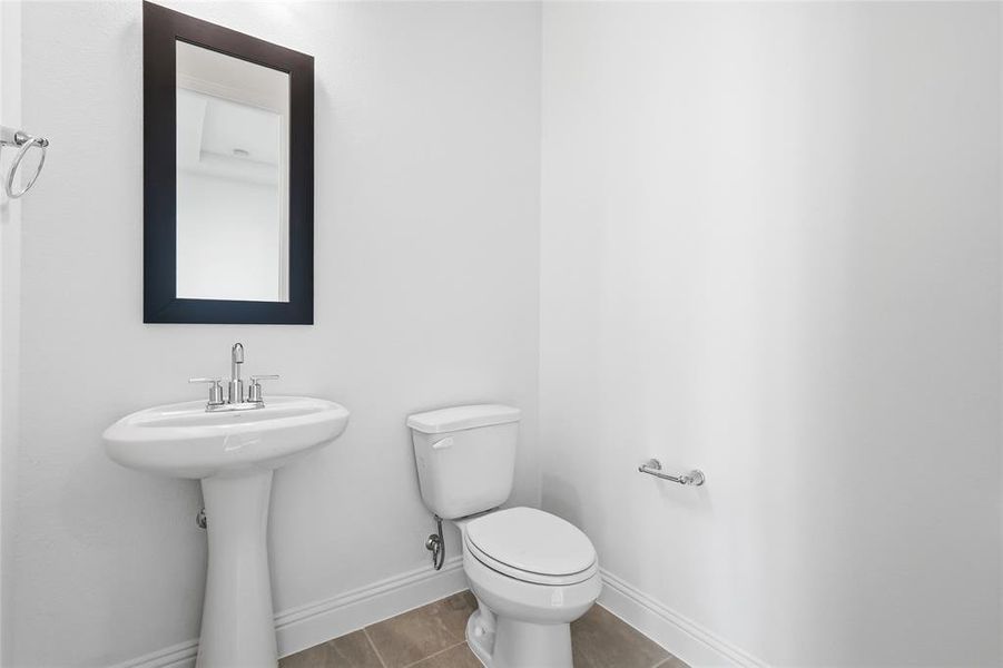 Half bath with toilet and tile patterned flooring Half bath with toilet and tile patterned flooring