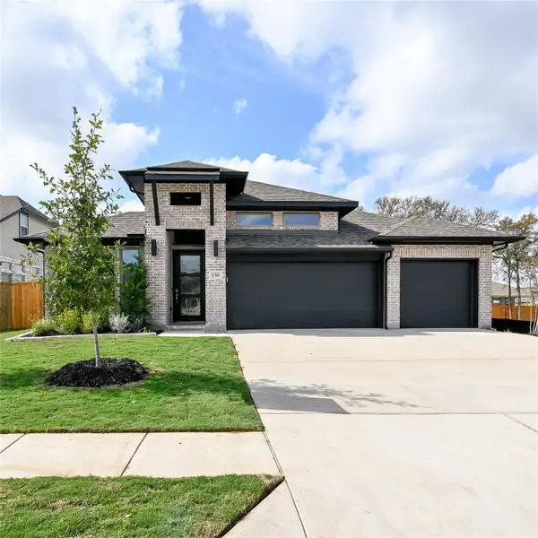 Prairie-style home with brick siding, roof with shingles, a garage, and driveway Prairie-style home with brick siding, roof with shingles, a garage, and driveway