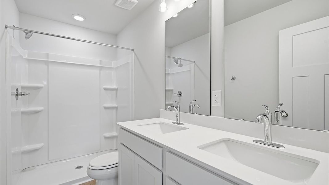 Memorable mornings begin in this elegant primary bathroom with walk-in shower and double vanity Memorable mornings begin in this elegant primary bathroom with walk-in shower and double vanity