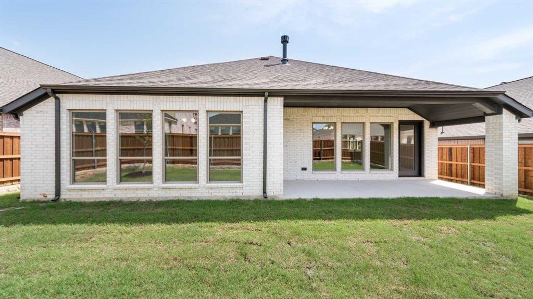 Back of house featuring a yard and a patio area