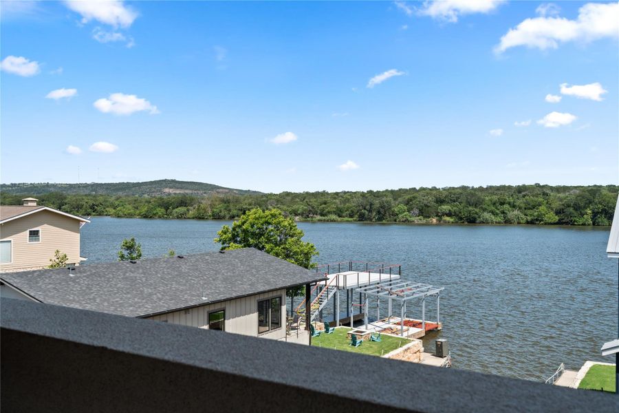 This photo showcases a serene lake view from a home, featuring nearby docks and lush greenery, perfect for waterfront living.