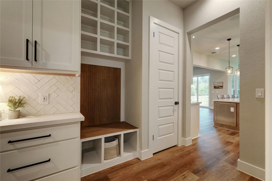 Built-in mudroom cabinetry with a wood-finish bench and cubby storage
