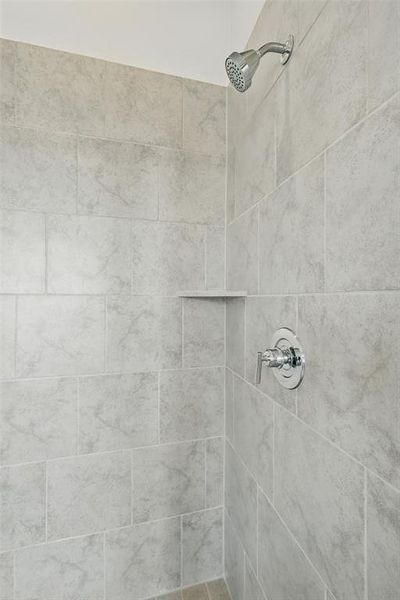 Room details featuring tiled shower Room details featuring tiled shower