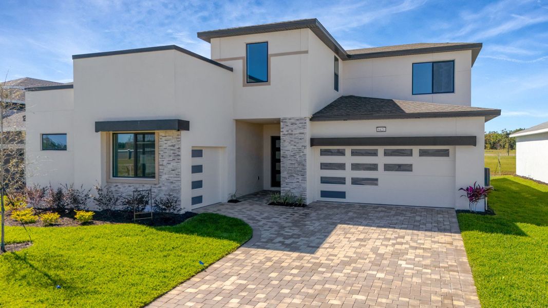 The Front Elevation of a DRB Homes Grand Hawk which is offered as a home plan at Serengeti in Spring Hill, FL.