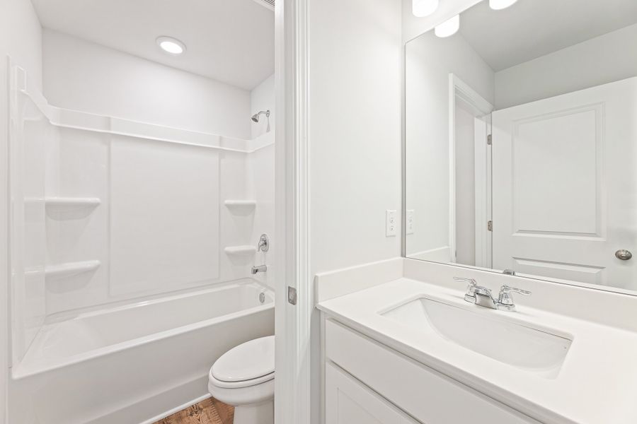 A bathroom with a tub sink and toilet. A bathroom with a tub sink and toilet.