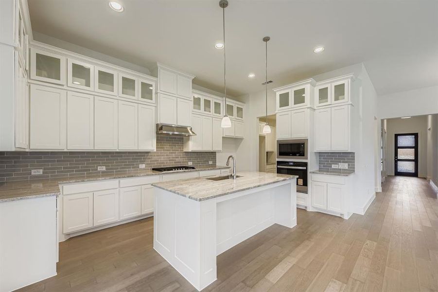 Kitchen with backsplash, white cabinets, appliances with stainless steel finishes, and recessed lighting Kitchen with backsplash, white cabinets, appliances with stainless steel finishes, and recessed lighting
