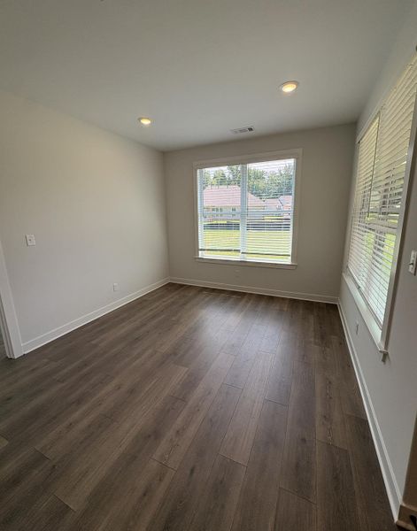 Room with wood-finish flooring, recessed lighting, and white walls Room with wood-finish flooring, recessed lighting, and white walls