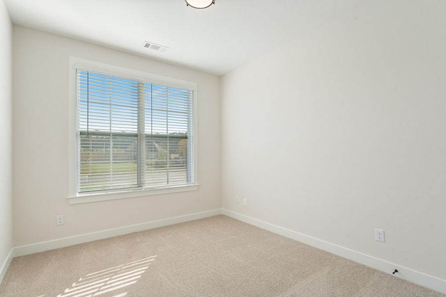 Light-filled room featuring neutral wall tones and a window with blinds