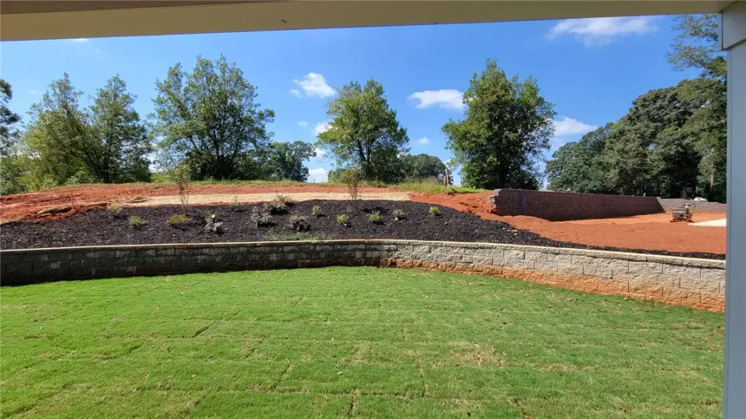 Green lawn gives way to a stone retaining wall and