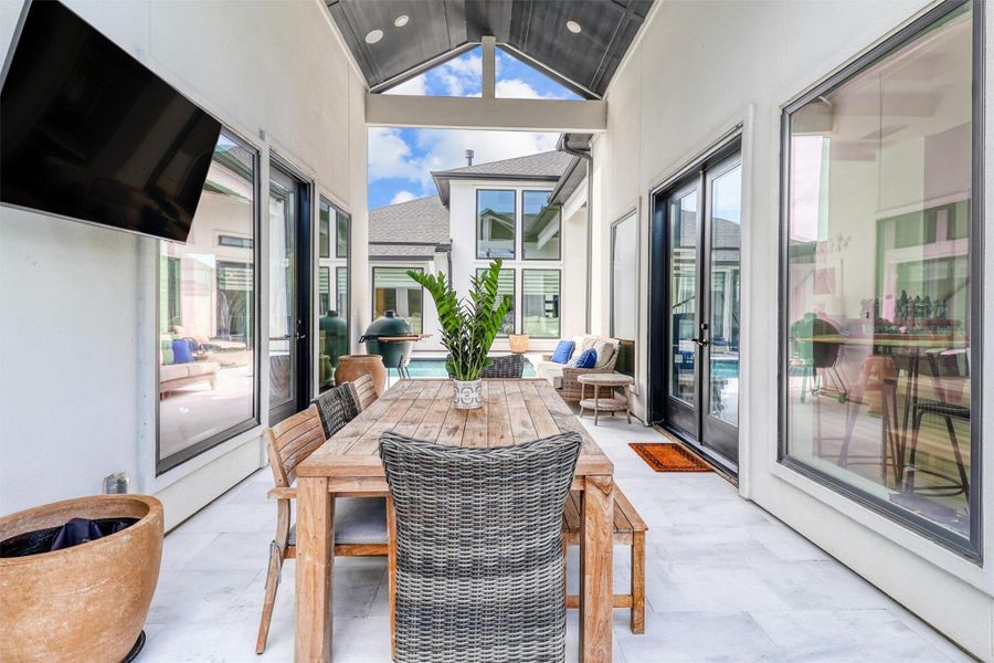 Covered breezeway between the main home and the casita has a vaulted ceiling with recessed lighting. This area is fantastic for outdoor entertaining, watching the game, and enjoying the pool and bar.