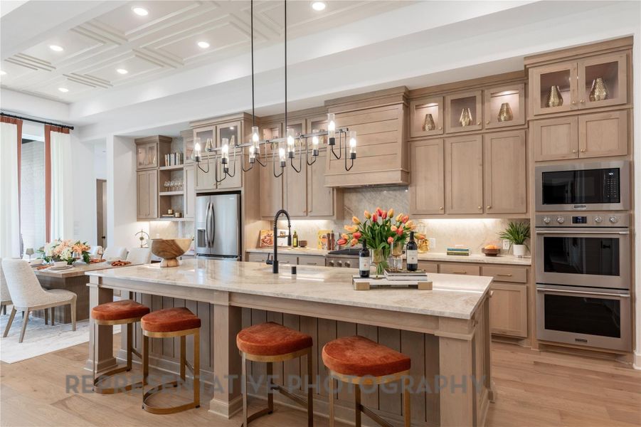 Kitchen featuring tasteful backsplash, appliances with stainless steel finishes, an island with sink, and light wood finished floors Kitchen featuring tasteful backsplash, appliances with stainless steel finishes, an island with sink, and light wood finished floors