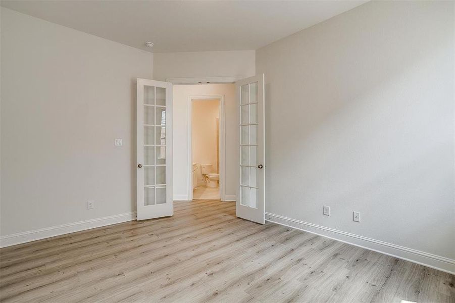 Unfurnished room with light hardwood / wood-style floors and french doors