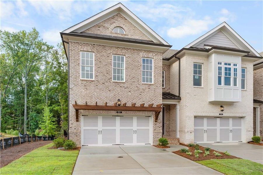 Front exterior of a new home in Ward's Crossing Townhomes, Johns Creek, GA, highlighting curb appeal (Image 29). Front exterior of a new home in Ward's Crossing Townhomes, Johns Creek, GA, highlighting curb appeal (Image 29).