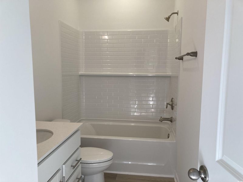 Bathroom with vanity,  shower combination, and wood finished floors