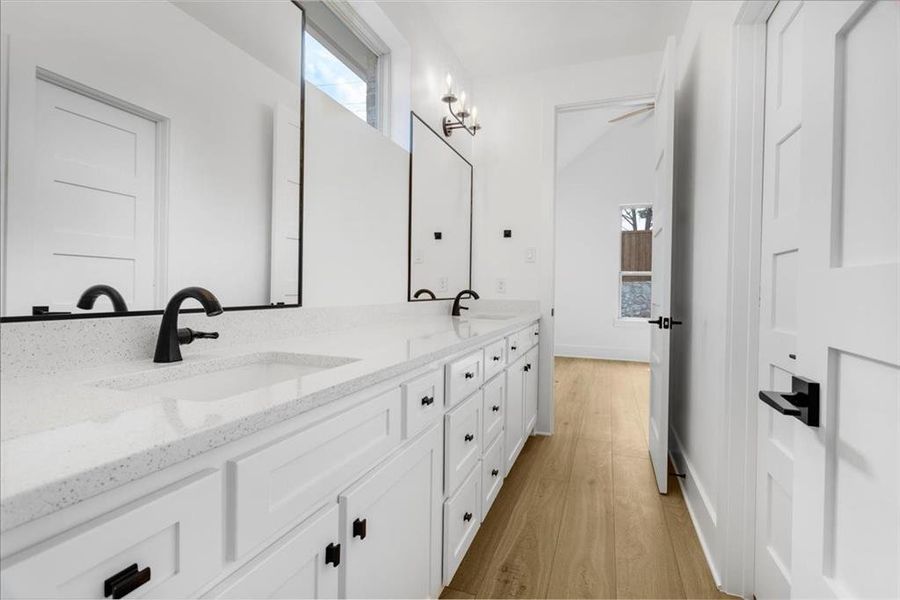Full bathroom with double vanity and light wood-style flooring