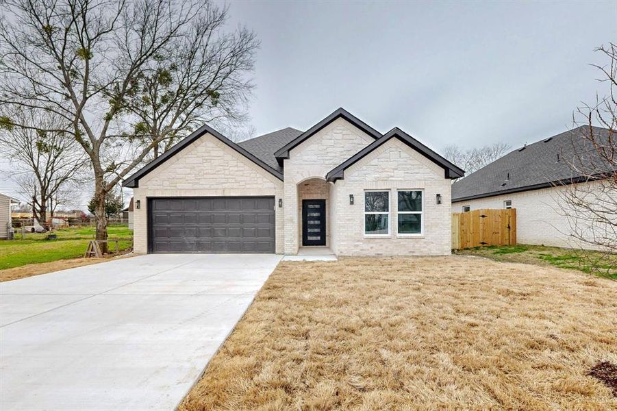 View of front of house featuring a garage and a front lawn