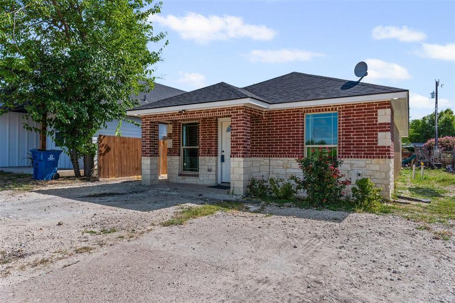 View of front of property featuring roof with shingles, brick siding, and stone siding View of front of property featuring roof with shingles, brick siding, and stone siding
