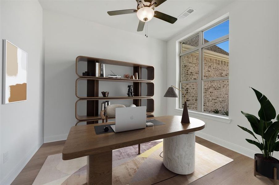 Spacious room featuring wood-finish flooring and a contemporary ceiling fan Spacious room featuring wood-finish flooring and a contemporary ceiling fan