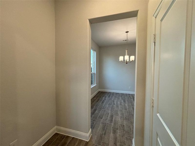 Unfurnished room with dark hardwood / wood-style flooring and a chandelier