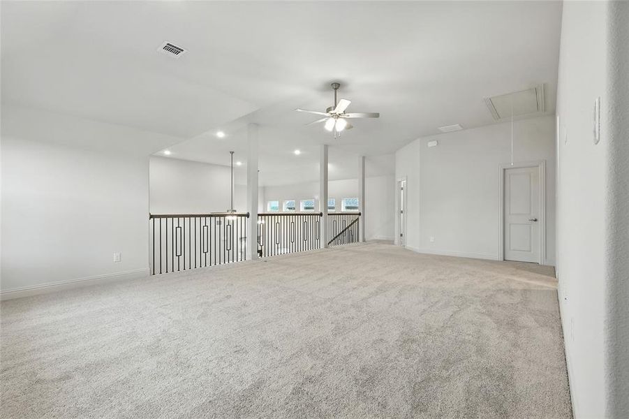 Carpeted empty room featuring ceiling fan, attic access, and recessed lighting