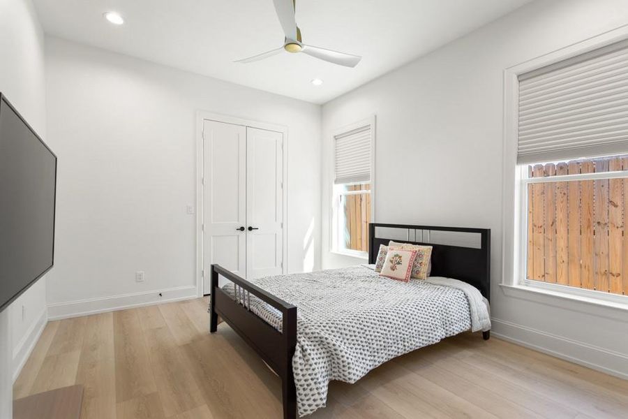 Bedroom featuring light wood-style flooring, recessed lighting, ceiling fan, and a closet