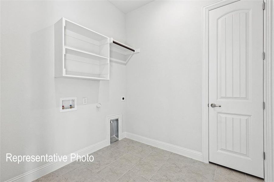 Clothes washing area with electric dryer hookup, light tile patterned floors, hookup for a gas dryer, and hookup for a washing machine