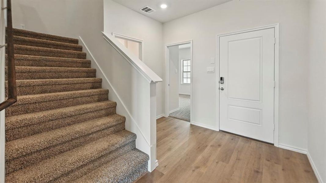 Foyer featuring stairs, light wood-style floors, and recessed lighting