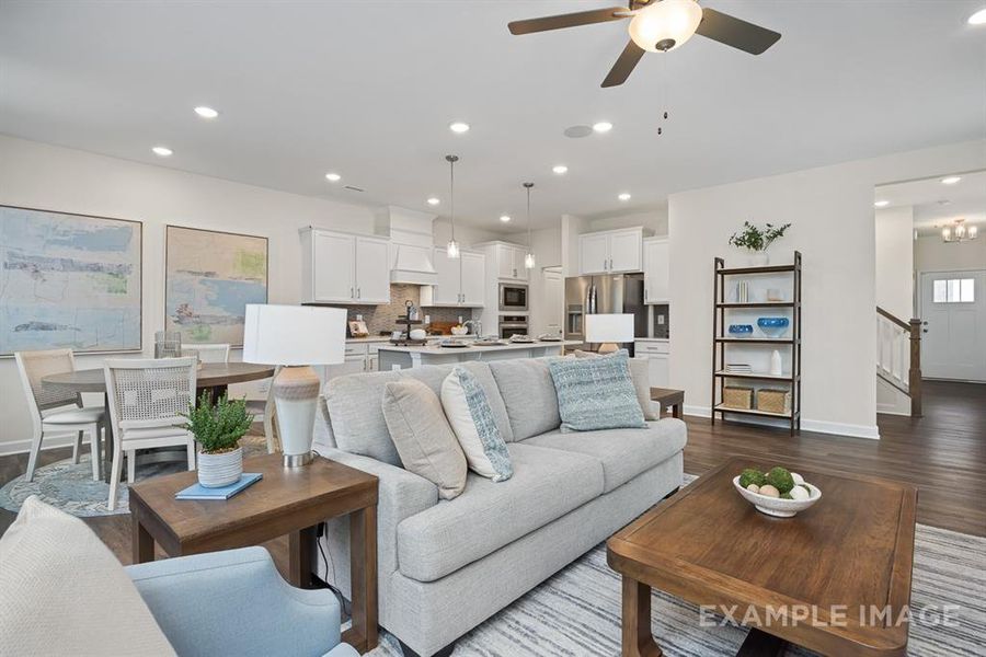 Living room with ceiling fan and dark hardwood / wood-style floors