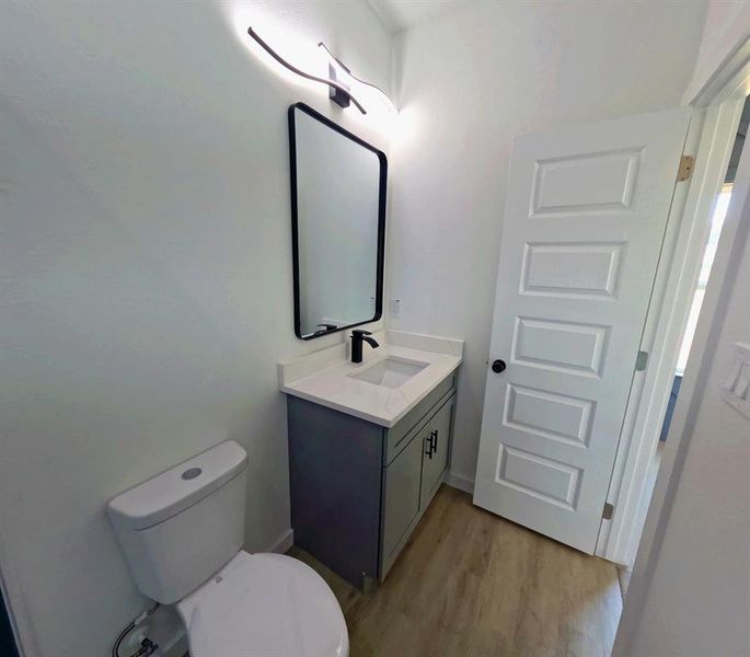 Half bath featuring vanity and light wood-type flooring Half bath featuring vanity and light wood-type flooring