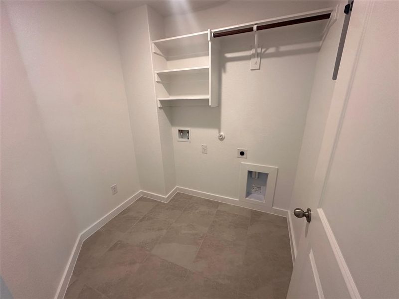 Laundry area featuring gas dryer hookup, washer hookup, hookup for an electric dryer, and light tile patterned flooring Laundry area featuring gas dryer hookup, washer hookup, hookup for an electric dryer, and light tile patterned flooring