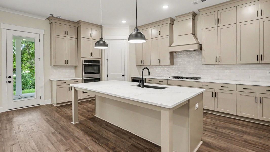 Kitchen with quartz countertops, tile backsplash, and light cabinetry Kitchen with quartz countertops, tile backsplash, and light cabinetry