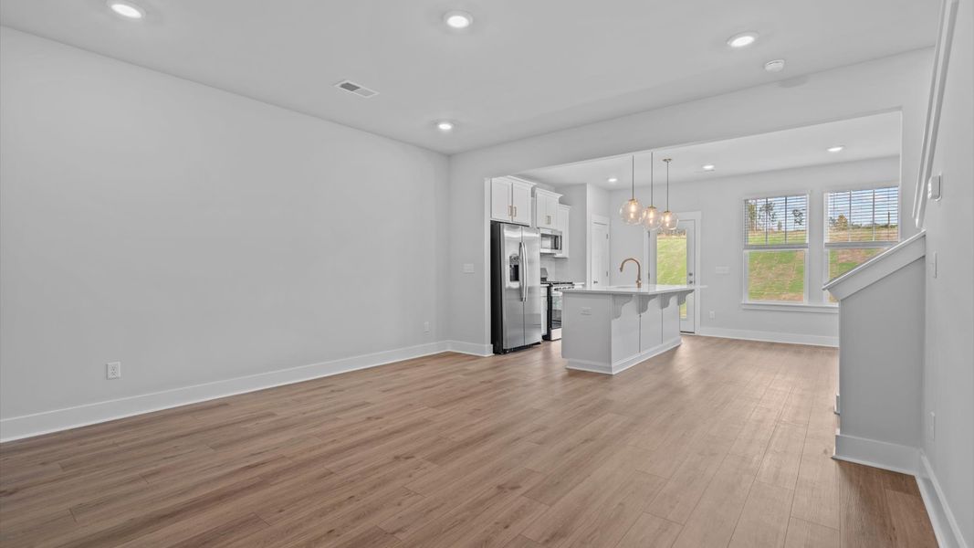 Spacious family room with rich hardwood flooring and elegant trim work in a reputable DRB Homes build Spacious family room with rich hardwood flooring and elegant trim work in a reputable DRB Homes build