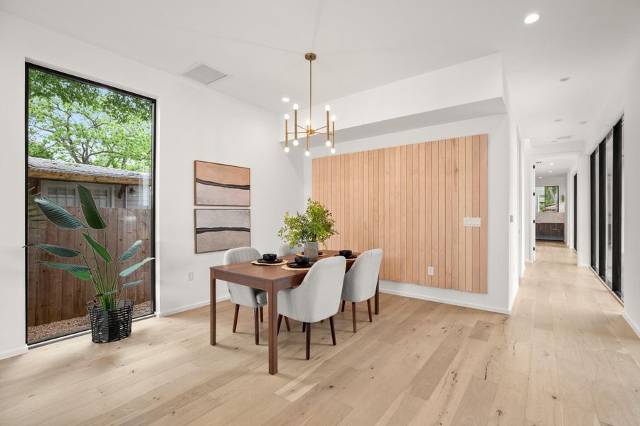 Dining room with light wood finished floors and a chandelier