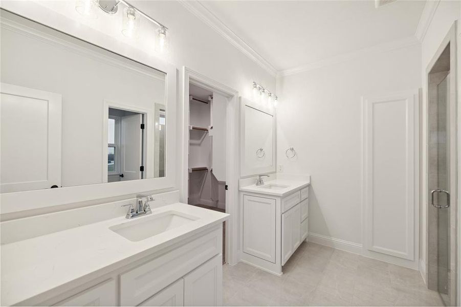 Bathroom with ornamental molding, walk in shower, and vanity