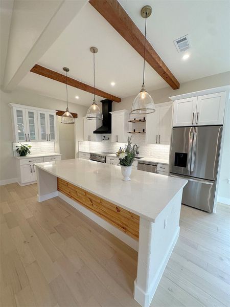 Kitchen featuring white cabinetry with glass fronts, decorative backsplash, stainless steel appliances, beam ceiling, and recessed lighting