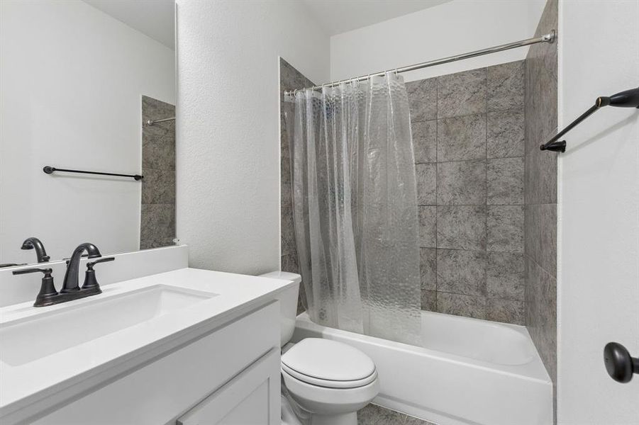 Bathroom featuring a white vanity with integrated sink, dark bronze-finish faucet, and a large wall mirror