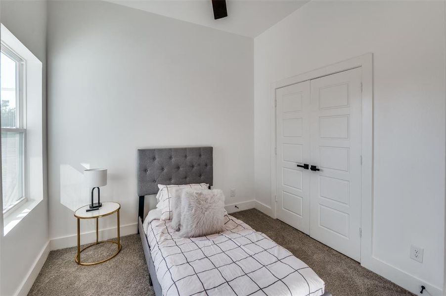 Bedroom featuring ceiling fan, multiple windows, a closet, and carpet flooring