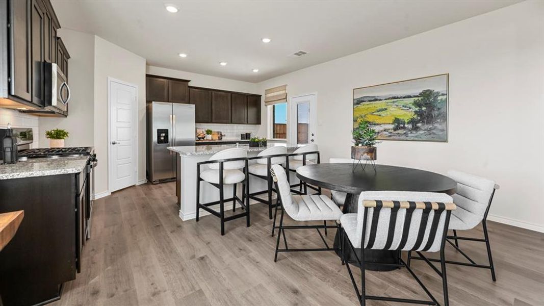 Dining area with recessed lighting and light wood-type flooring Dining area with recessed lighting and light wood-type flooring