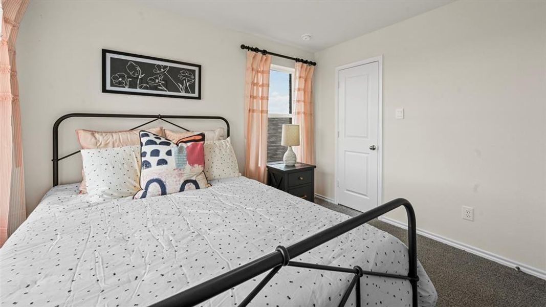 Bedroom with dark colored carpet and baseboards