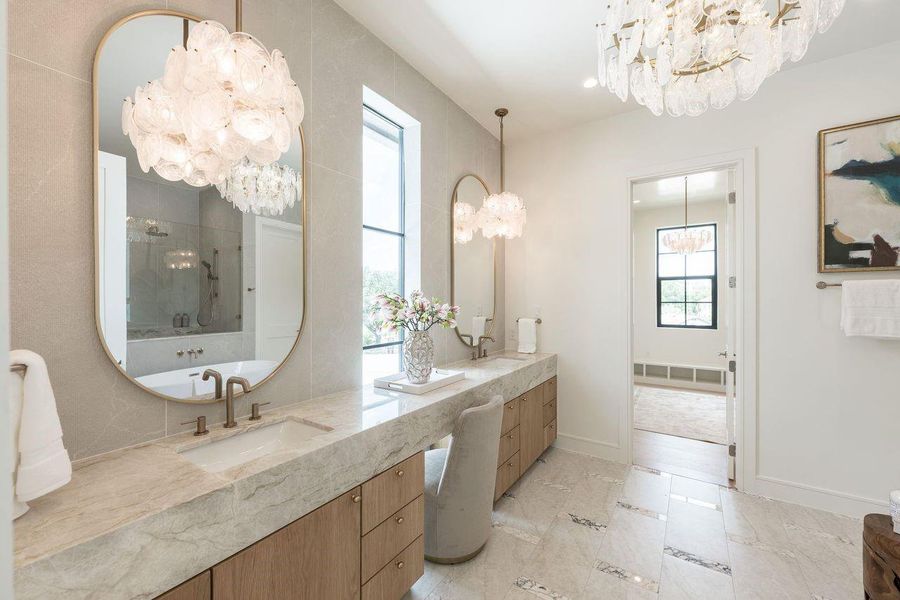 Elevated and effortlessly refined, this dual-sink vanity pairs textured wall finishes with sleek quartz surfaces and curated lighting. Built-in niches provide gallery-worthy storage, blending practicality with a high-design aesthetic.
