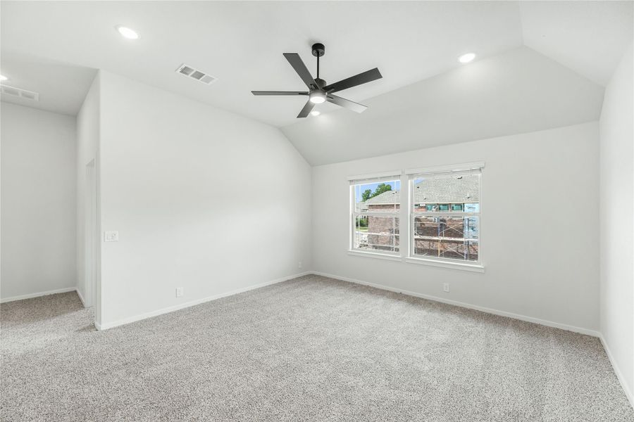 Empty bedroom with vaulted ceiling, black ceiling fan, carpet flooring, and a double window