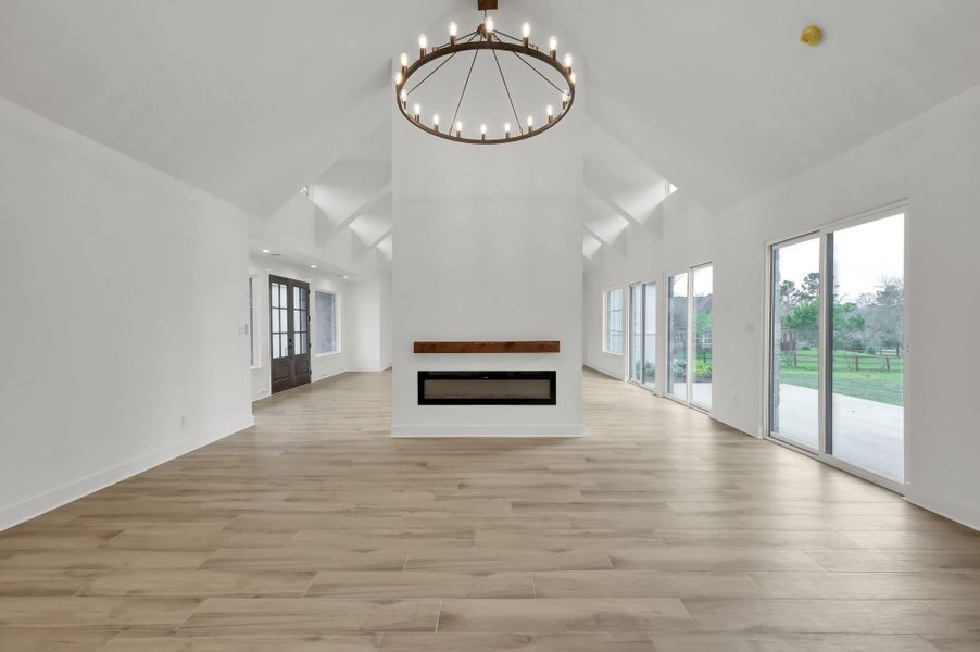 Expansive living room showcasing architectural ceiling details, abundant natural light, and large sliding doors leading to the outdoor living space.