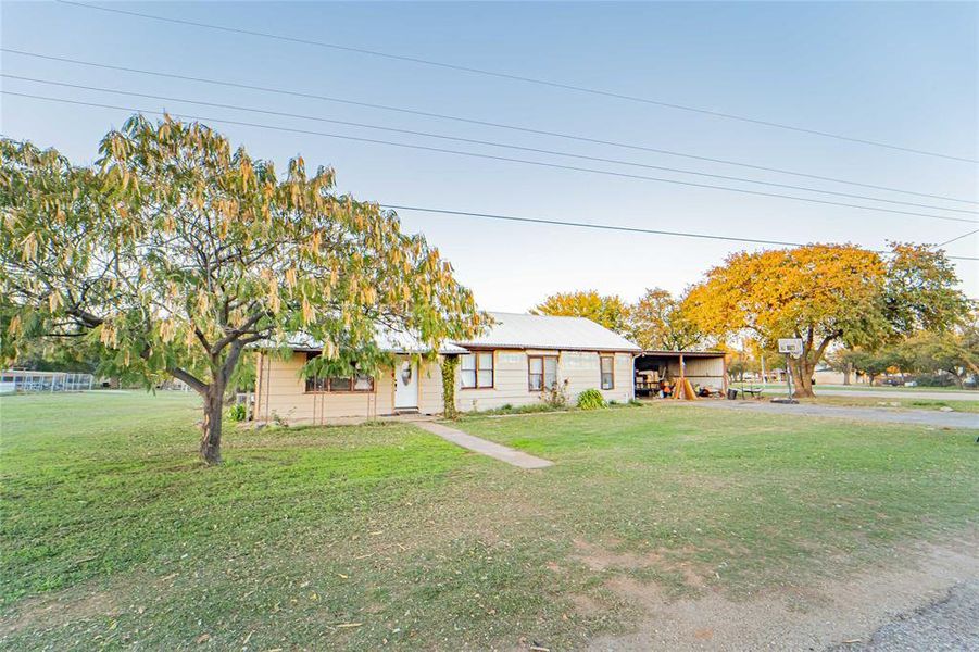 View of front of home featuring a front yard and a carport View of front of home featuring a front yard and a carport